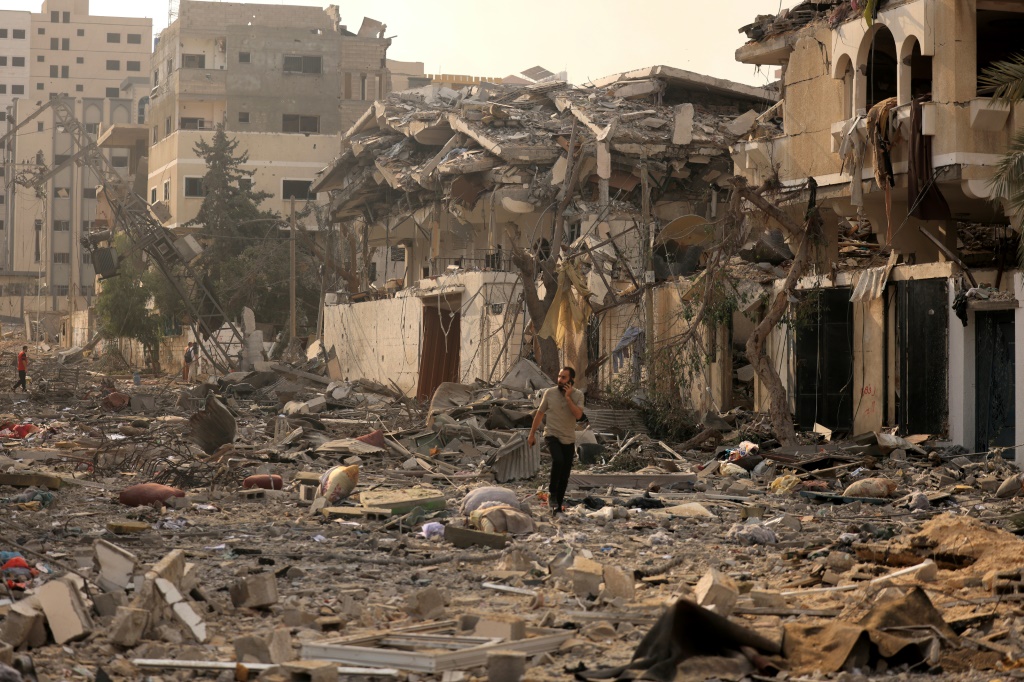 رجل فلسطيني يسير بين آثار الدمار الذي خلفه القصف الإسرائيلي على قطاع غزة في العاشر من تشرين الأول/أكتوبر 2023 (أ ف ب)  &nbsp;