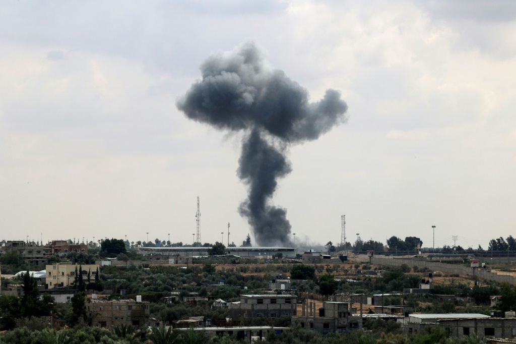 دخان يتصاعد فوق معبر رفح الحدودي في غزة مع مصر، وهو المعبر الوحيد الذي يتجاوز إسرائيل، في أعقاب غارة جوية إسرائيلية يوم الثلاثاء. (ا ف ب)   