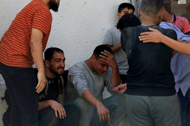 فلسطينيون خارج مستشفى الشفاء في مدينة غزة يبكون اقرباء لهم قتلوا في قصف إسرائيلي في السابع من تشرين الأول/أكتوبر 2023 (أ ف ب)