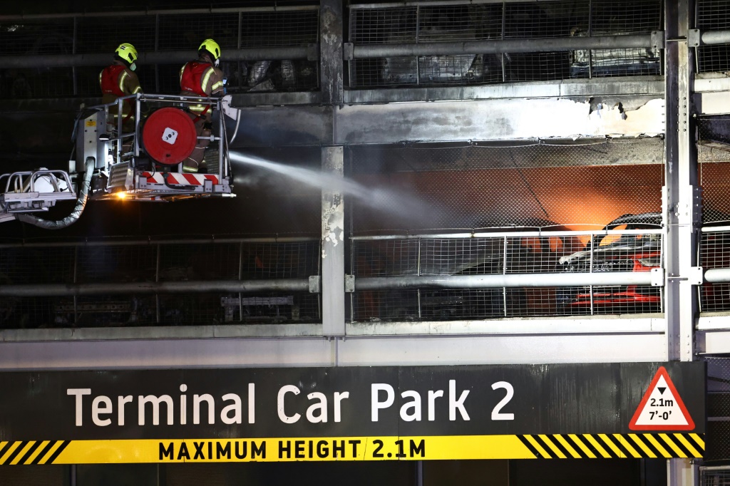 رجال الإطفاء يكافحون حريقًا في مطار لوتون بلندن مما تسبب في انهيار جزئي لمبنى انتظار السيارات (ا ف ب)