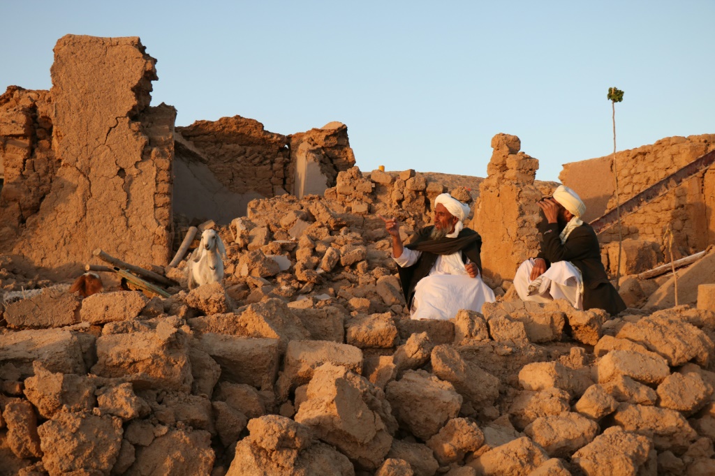 سكان يجلسون فوق ركام نزل دمره الزلزال في قرية ساربولاند الواقعة في منطقة زندي جان في ولاية هرات بتاريخ 7 تشرين الأول/أكتوبر 2023 (ا ف ب)