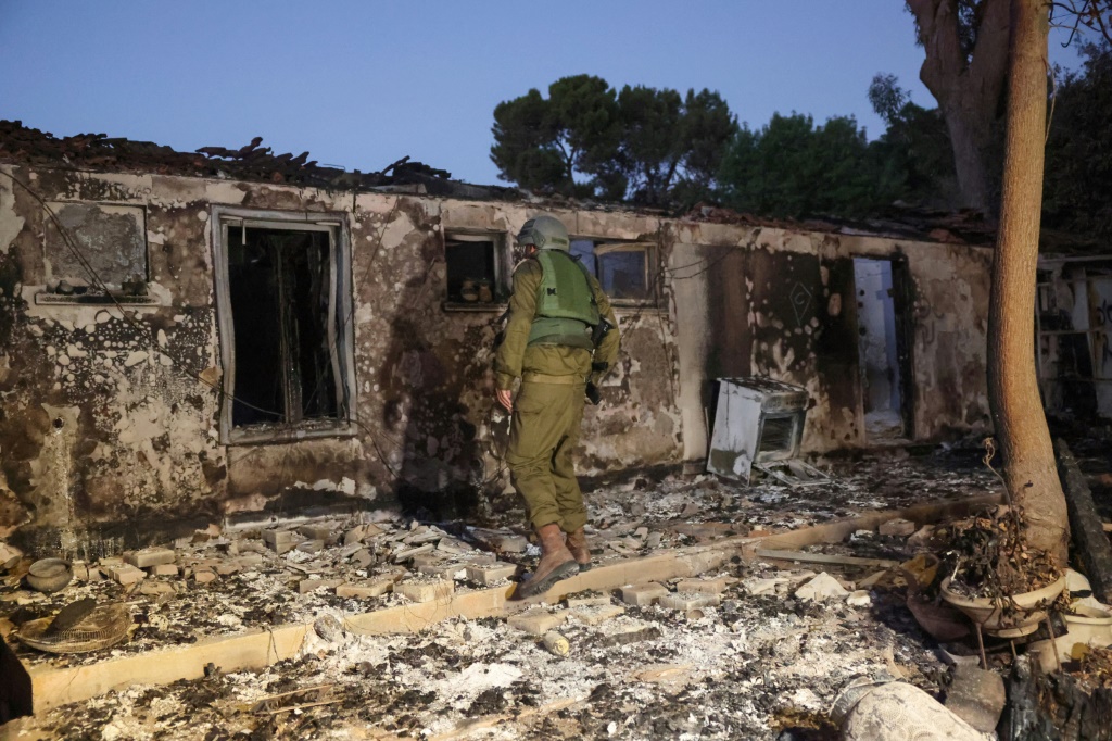 عنصر أمن إسرائيلي يتفقد مبنى مدمرا في كيبوتس يئيري قرب الحدود مع غزة بعد أيام من عملية تسلل قام بها مسلحون فلسطينيون، في 11 تشرين الأول/أكتوبر 2023 (أ ف ب)   