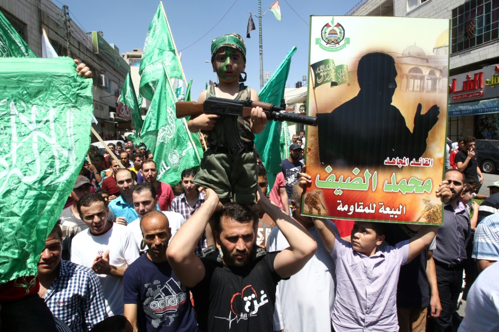 مناصرو حماس في الضفة الغربية يحملون صورة ظلية للقائد العسكري المراوغ محمد ضيف، الذي لم يتم تصويره تقريبًا بعد محاولات اغتيال متكررة قامت بها إسرائيل (ا ف ب)