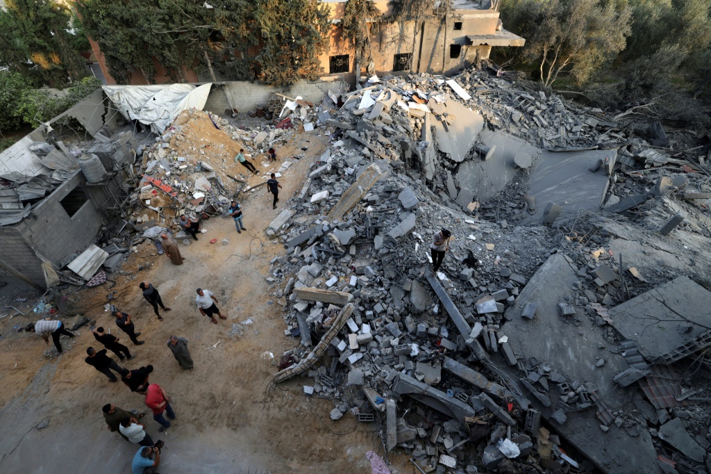 سكان يتفقدون الأضرار التي لحقت بمبنى بعد الغارات الإسرائيلية على مخيم رفح بجنوب قطاع غزة في 14 تشرين الأول/أكتوبر 2023 (ا ف ب)