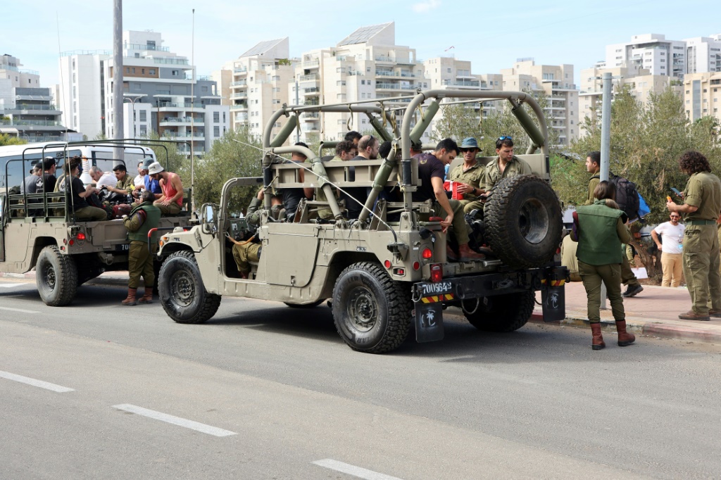 جنود احتياط في الجيش الإسرائيلي يتم نقلهم في مركبات عسكرية للانضمام إلى قاعدتهم العسكرية جنوب تل أبيب، 7 أكتوبر، 2023. (أ ف ب)   