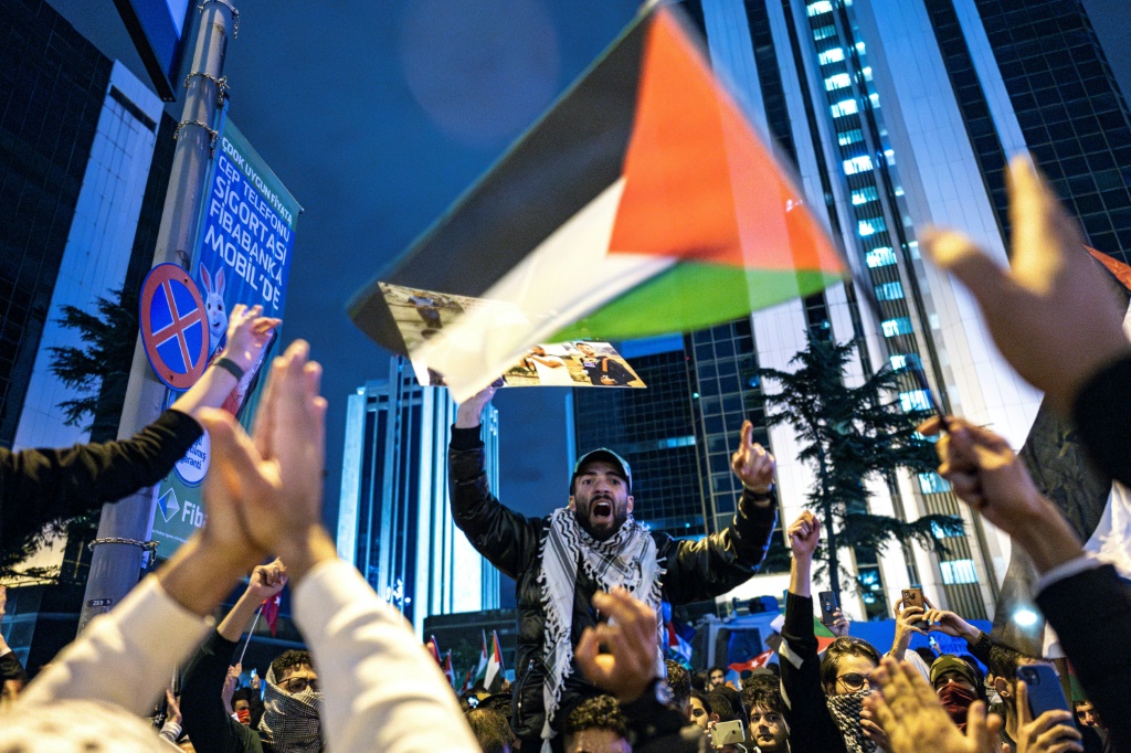 متظاهر يردد شعارات ويلوح بالعلم الفلسطيني خلال مسيرة لدعم الفلسطينيين في 18 أكتوبر 2023. (أ ف ب)