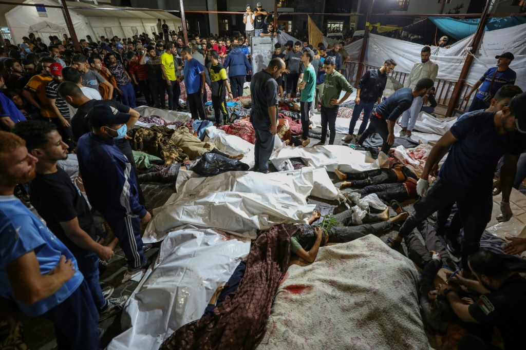  حشد من الناس تجمعوا حول جثث فلسطينيين قتلوا في ضربة على مستشفى الأهلي العربي بوسط غزة، ونقلوا إلى مستشفى الشفا، في 17 تشرين الأول/أكتوبر 2023 (أ ف ب)   