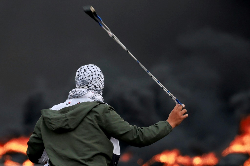 فلسطيني يرشق القوات الإسرائيلية بالحجارة خلال مظاهرة ضد القصف الإسرائيلي على قطاع غزة، في مدينة رام الله بالضفة الغربية المحتلة في 11 أكتوبر 2023 (أ ف ب)   