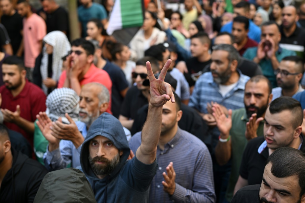 رجل فلسطيني يرفع علامة النصر خلال مظاهرة في رام الله بالضفة الغربية المحتلة في 18 أكتوبر 2023، احتجاجًا على قصف مستشفى في غزة أدى إلى مقتل المئات في اليوم السابق. (أ ف ب)