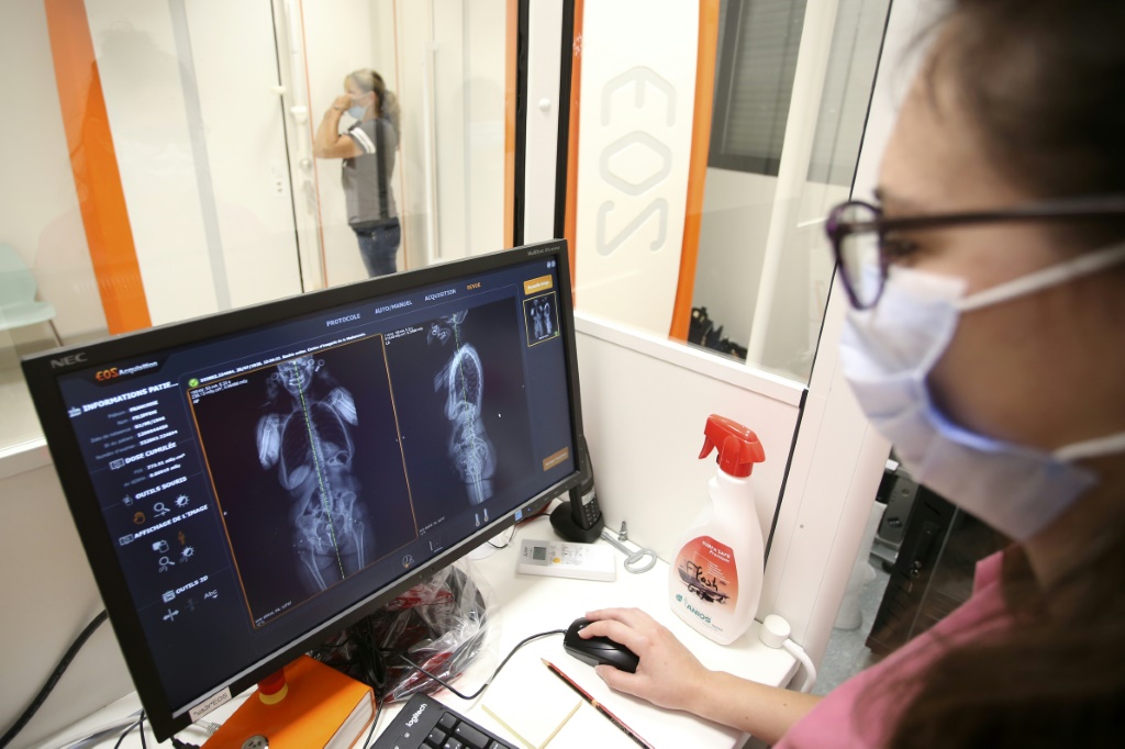 طبيبة أشعة تنظر إلى شاشة الكومبيوتر بينما تتحضر مريضة لإجراء تصوير شعاعي في أحد مراكز أجاكسيو الصحية في 20 تموز/يوليو 2020 (ا ف ب)