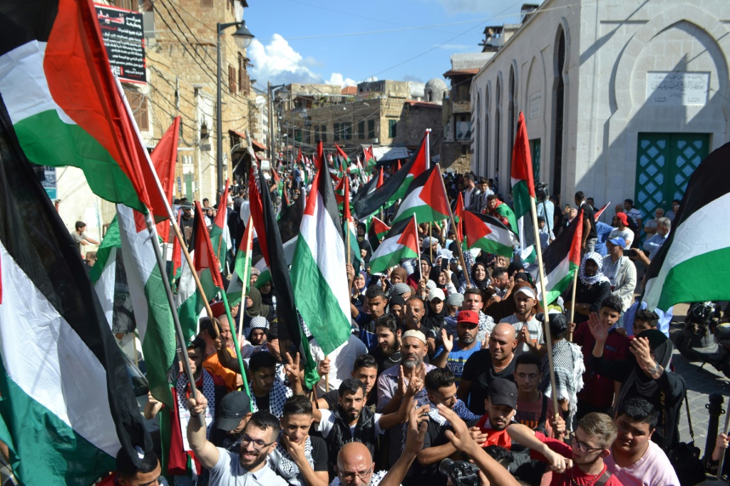 متظاهرون يرفعون العلم الفلسطيني خلال تظاهرة تأييد للشعب الفلسطيني بعد صلاة الجمعة في مدينة طرابلس شمال لبنان في 20 تشرين الأول/أكتوبر 2023 (أ ف ب)   