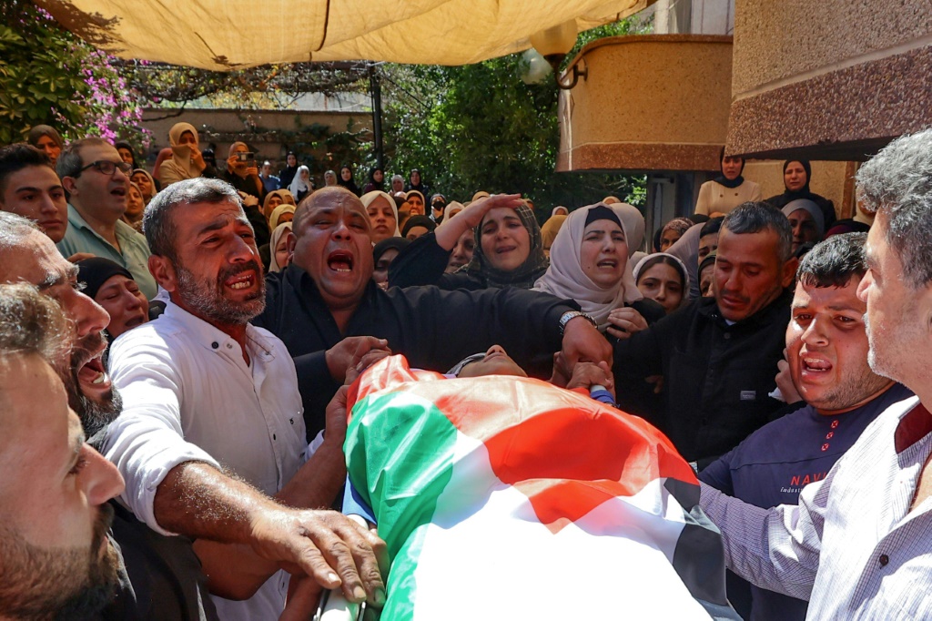 أقارب يرافقون جثمان عدي منصور (17 عاما) بعد يوم من مقتله خلال مواجهات مع جنود إسرائيليين عند حاجز عسكري قرب حوارة، خلال جنازته في قرية كفر قليل بالضفة الغربية المحتلة في 21 تشرين الأول/أكتوبر 2023 (أ ف ب)  &nbsp;