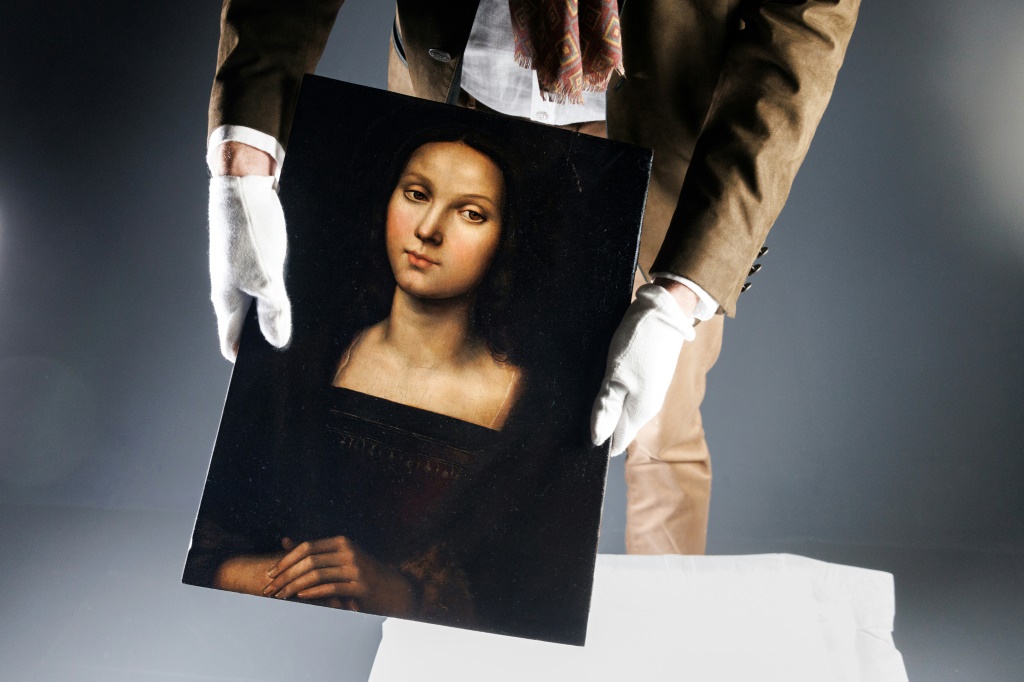 رجل يعرض في باريس لوحة لمريم المجدلية نُسبت إلى رسام عصر النهضة الإيطالي رفائيل، في 21 تشرين الأول/أكتوبر 2023 (ا ف ب)