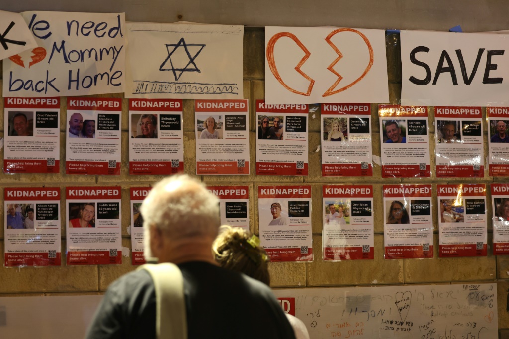    أشخاص يتجمعون بجوار جدار في تل أبيب يحملون صور المختطفين خلال هجوم 7 أكتوبر على جنوب إسرائيل (أ ف ب)   