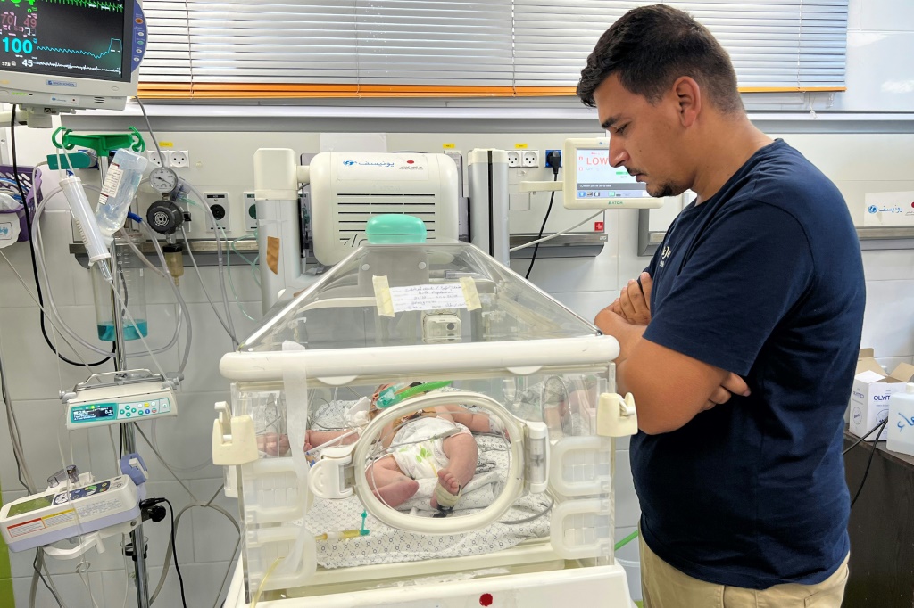 أيمن أبو شمالة (34 عامًا) يقف قرب حاضنة ابنته مكّة حديثة الولادة في مستشفى الهلال الأحمر الإماراتي في رفح في 23 تشرين الأول/أكتوبر 2023 (ا ف ب)