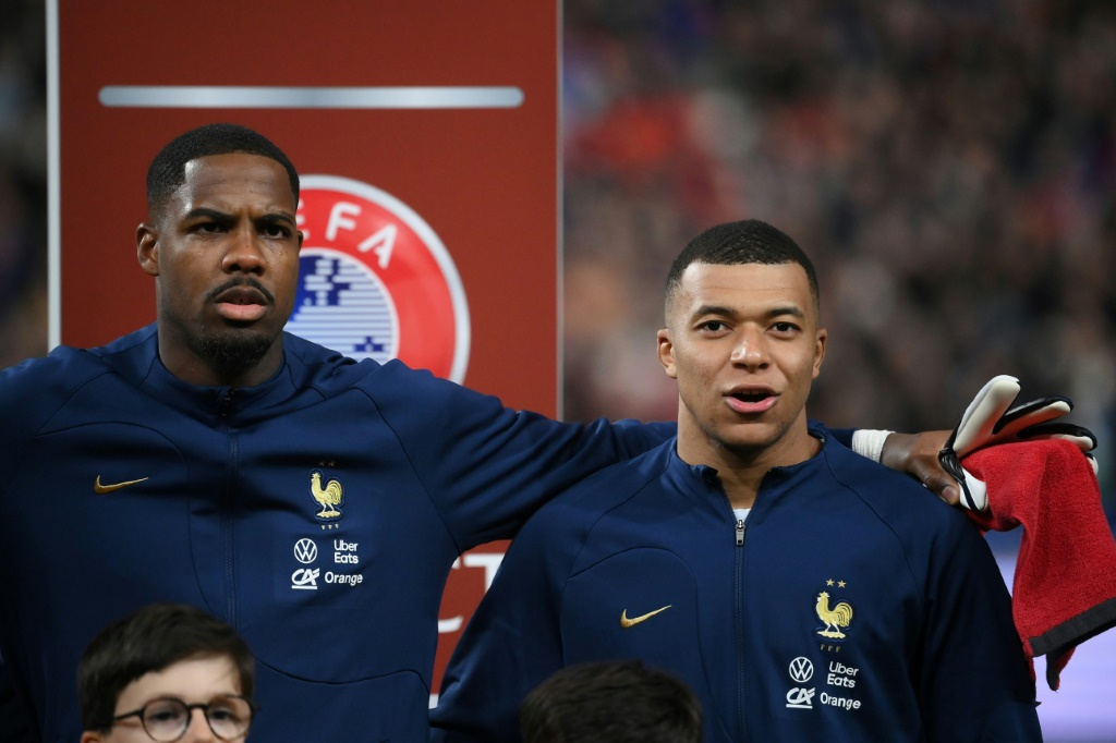 حارس المرمى المنتخب الفرنسي مايك مينيان (يسار) وزميله المهاجم كيليان مبابي خلال عزف النشيد الوطني في المباراة ضد هولندا في تصفيات كأس أوروبا 2024 في ملعب فرنسا في سان دوني في 24 آذار/مارس 2023 (ا ف ب)