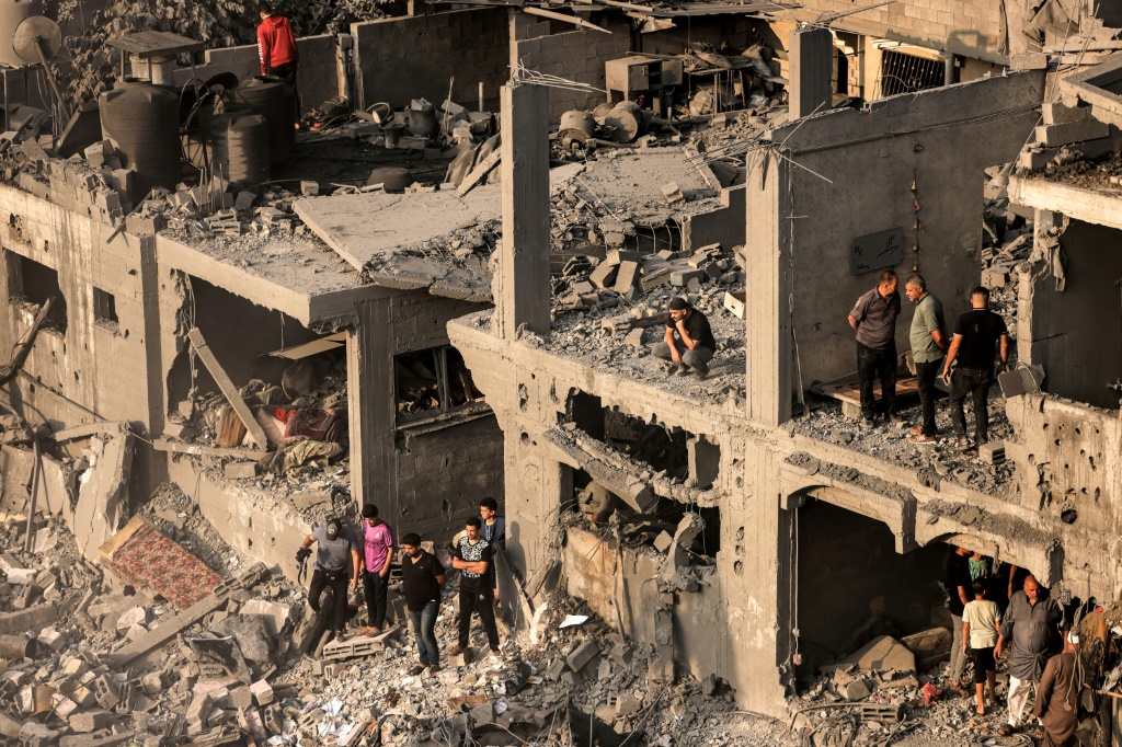 أشخاص يبحثون عن ناجين وجثث ضحايا من خلال المباني التي دمرت خلال القصف الإسرائيلي في خان يونس جنوب قطاع غزة في 25 أكتوبر 2023 (أ ف ب)  &nbsp;