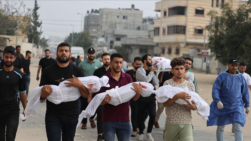 أهالي في غزة يحملون جثامين أطفالهم الذين قتلهم القصف الاسرائيلي (الأناضول)