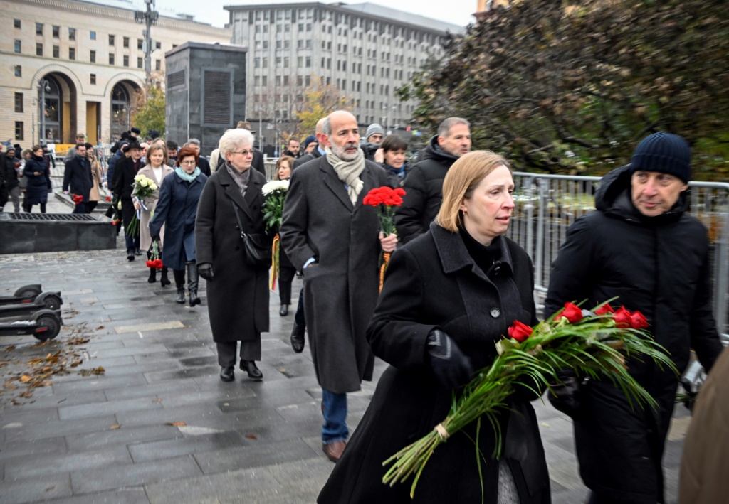 مبعوثون أجانب ومن بينهم السفيرة الأمريكية لين تريسي يضعون الزهور تكريما لذكرى ضحايا إرهاب ستالين خارج مقر جهاز الأمن الفيدرالي (كي جي بي السابق) في موسكو (ا ف ب)   