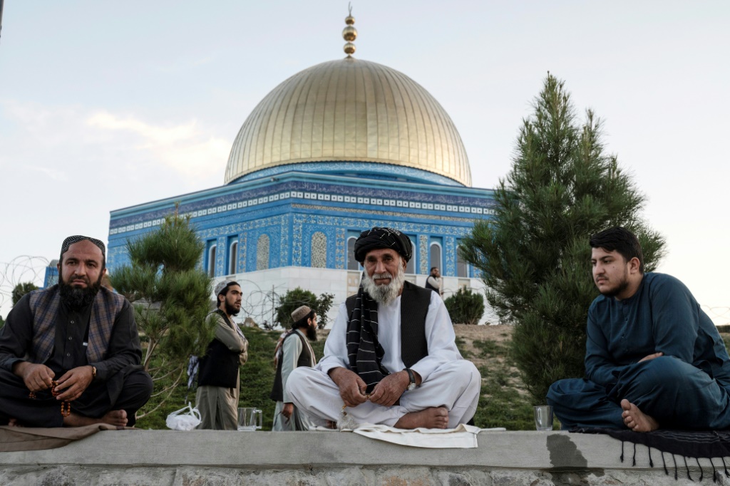 زوار يجلسون أمام مسجد يشبه "قبة الصخرة" في المسجد الأقصى، على قمة تل في كابول، 29 أكتوبر 2023 (أ ف ب)   