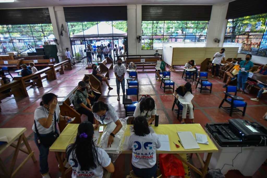 فيليبينيون يدلون بأصواتهم داخل كنيسة أقيم فيها مركز اقتراع في الانتخابات الرئاسية في مدينة كويزون بضواحي مانيلا في 9 أيار/مايو 2022 (ا ف ب)