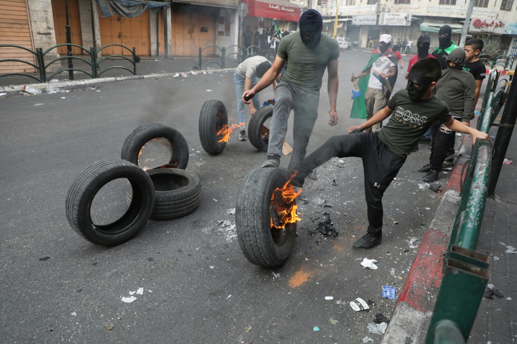 فلسطينيون يحرقون إطارات في مدينة الخليل في الضفة الغربية المحتلة في الأول من تشرين الثاني/نوفمبر 2023 (أ ف ب)  