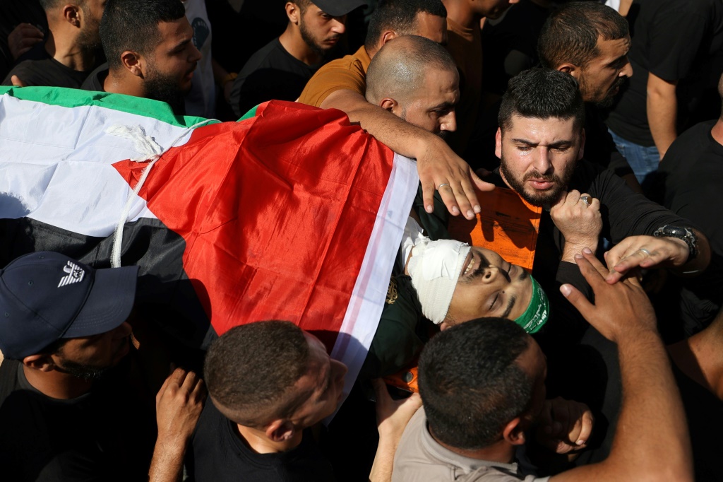 فلسطينيون يشيعون مقاتلًا قُتل خلال توغل ليلي واشتباكات مع الجيش الإسرائيلي في مخيم جنين للاجئين، بالقرب من مدينة جنين، في شمال الضفة الغربية المحتلة في 3 تشرين الثاني/نوفمبر 2023، وسط المعارك المستمرة بين إسرائيل وحركة حماس الفلسطينية في غزة (أ ف ب)