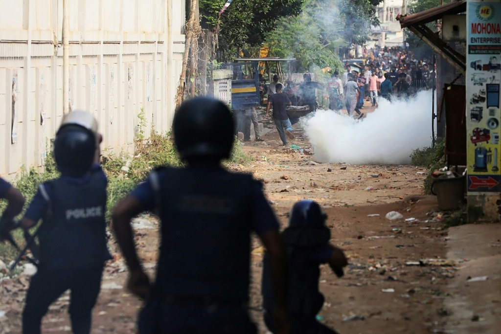    عناصر الشرطة يطلقون الغاز المسيل للدموع لتفريق عمّال الملابس الذين نظّموا تظاهرة للمطالبة بمضاعفة أجورهم في أشوليا في الرابع من تشرين الثاني/نوفمبر 2023 (أ ف ب)   
