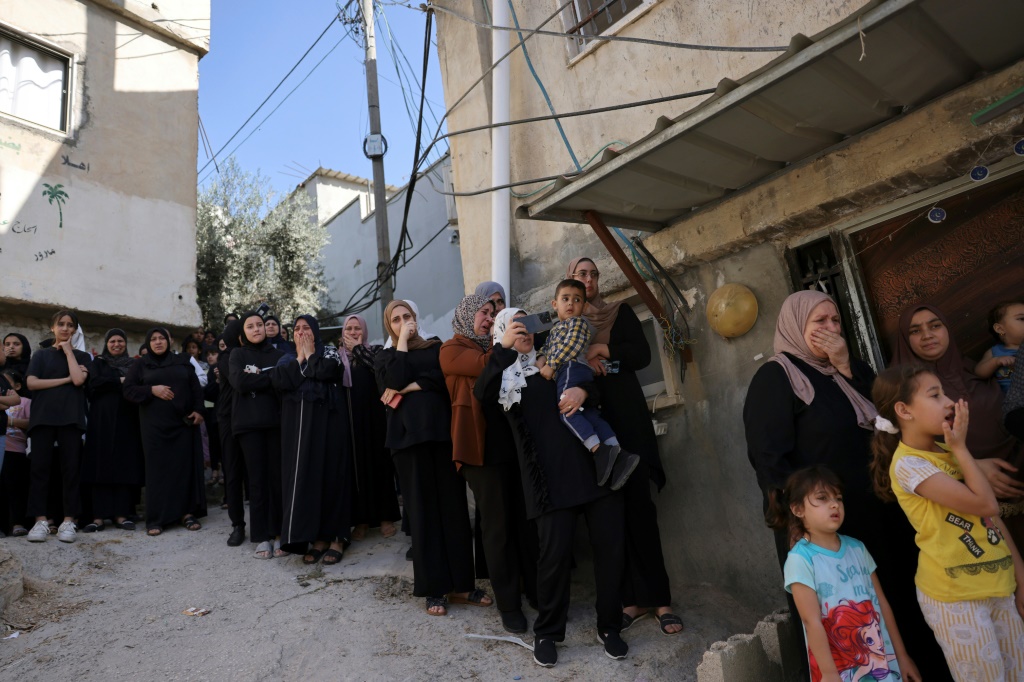 سيدات يراقبن تشييع فلسطينيون لجثماني شابين قتلا برصاص الجيش الإسرائيلي في مخيم الفوار جنوب مدينة الخليل في جنوب الضفة الغربيةالمحتلة في 3 تشرين الثاني/نوفمبر 2023 (ا ف ب)
