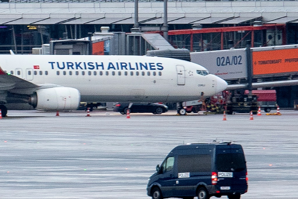 آلية للشركة على مقربة من طائرة للخطوط الجوية التركية بدت تحتها سيارة محتجز الرهائن على مدرج مطار هامبورع بشمال ألمانيا في 5 تشرين الثاني/نوفمبر 2023 (أ ف ب)   