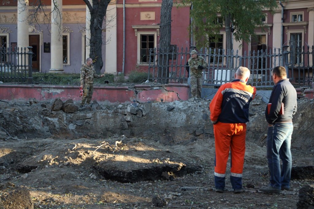 عمال الطوارئ يتفقدون حفرة خارج متحف فني، في أعقاب الضربة الروسية في أوديسا (أ ف ب)   