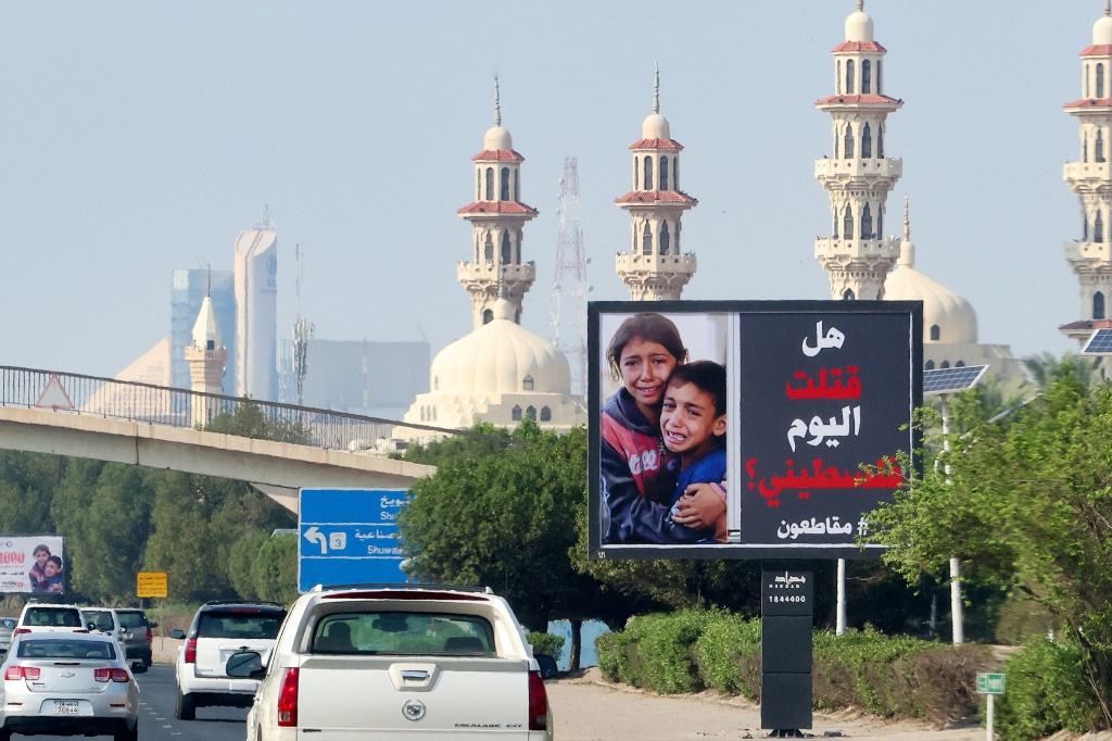 لوحة إعلانية تُظهر صورة طفلين فلسطينيين وشعارًا يقول "هل قتلت اليوم فلسطينيًا #مقاطعون" في الكويت في 26 تشرين الأول/أكتوبر 2023 (ا ف ب)
