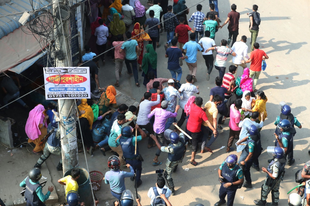 أفراد الأمن البنجلاديشيون يفرقون عمال الملابس المحتجين، الذين رفضوا زيادة الأجور التي عرضتها الحكومة باعتبارها غير كافية، في غازيبور خارج دكا (ا ف ب)   