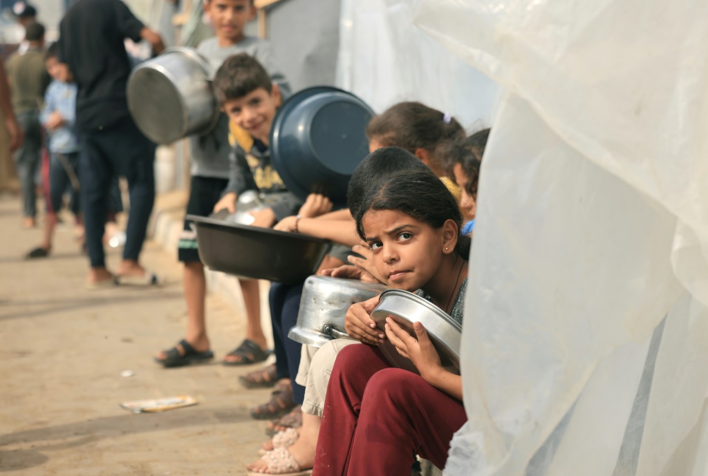 أطفال فلسطينيون نازحون ينتظرون الحصول على الطعام في خان يونس (أ ف ب)   
