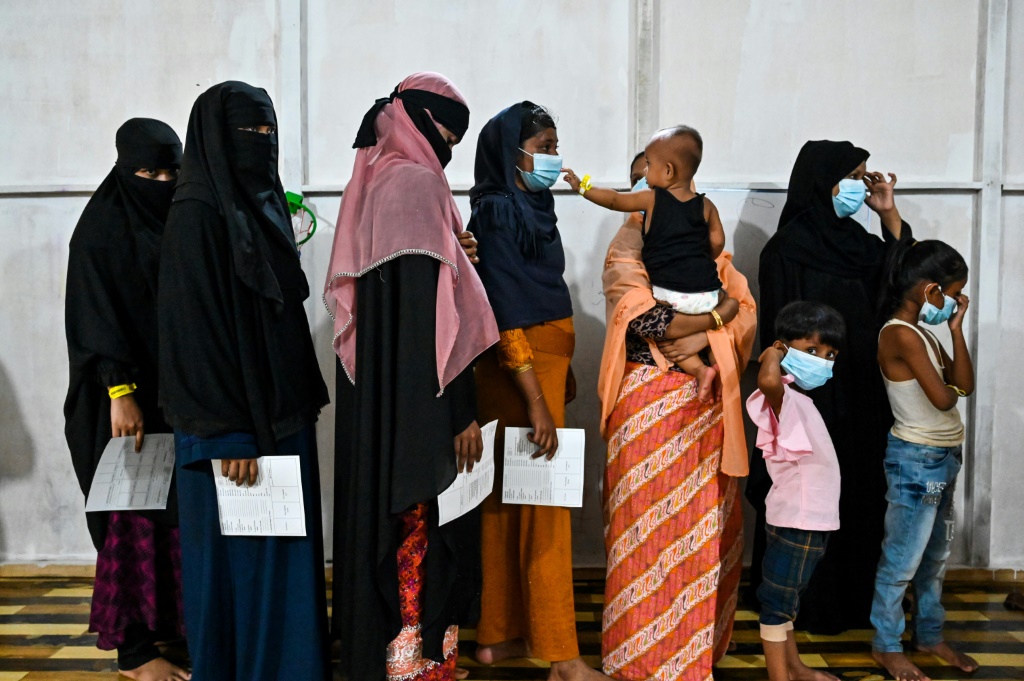 لاجئون من الروهينجا يصطفون في طابور للتحقق من هوياتهم في مأوى مؤقت في مقاطعة آتشيه بإندونيسيا (ا ف ب)