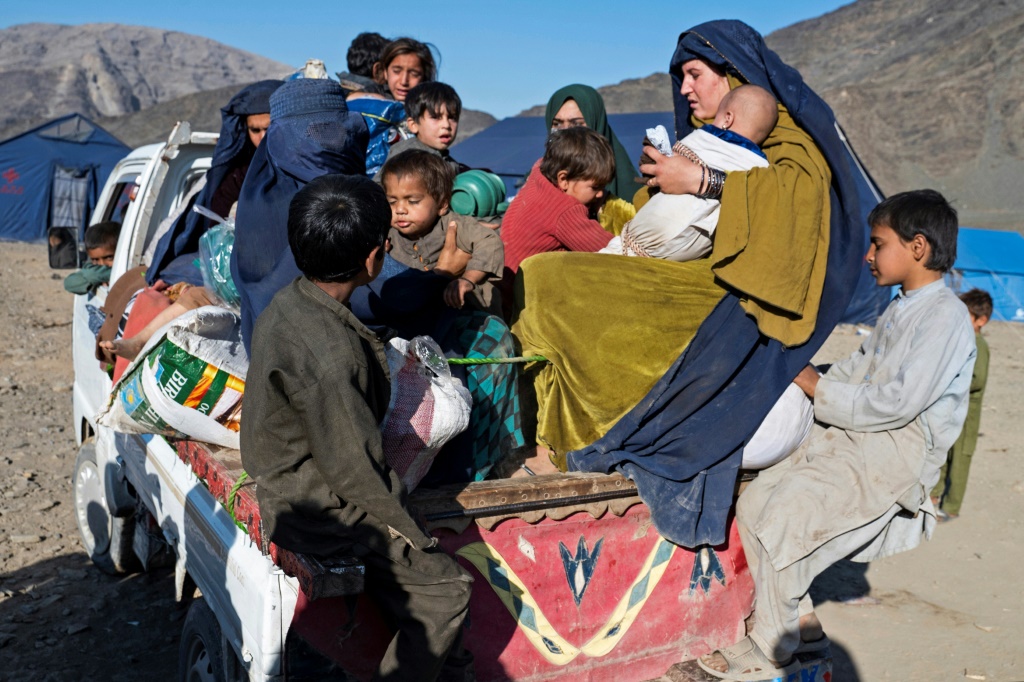 اللاجئة الأفغانية شازيا (الثانية على اليمين)، أم لثلاثة أطفال، تحمل رضيعًا على متن شاحنة مكتظة متوجهة إلى جلال آباد (أ ف ب)   