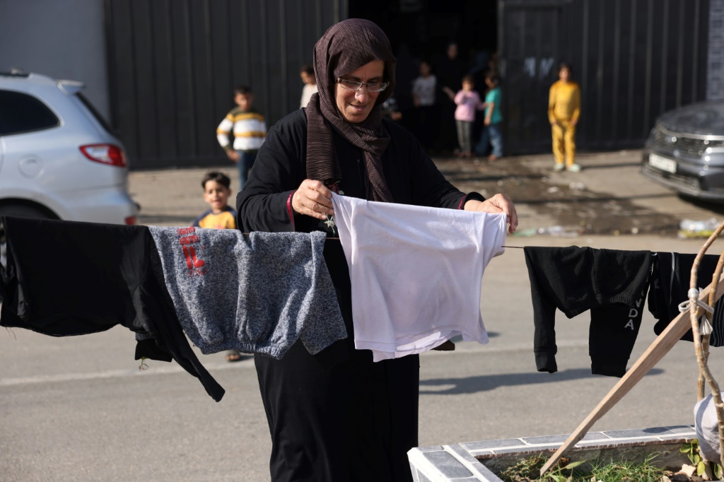 سيدة فلسطينية تنشر غسيل عائلتها في البريج في وسط قطاع غزة في 14 تشرين الثاني/نوفمبر 2023 (ا ف ب)