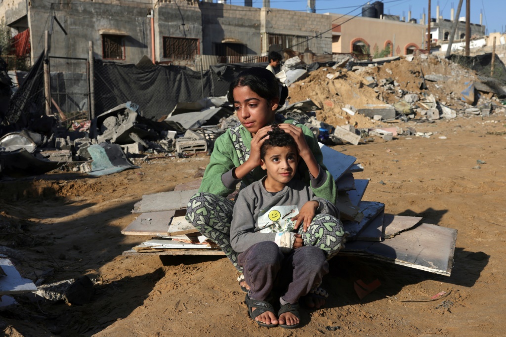 فتاة فلسطينية وشقيقها قرب منزل مدمر بفعل غارة اسرائيلية في رفح في 18 تشرين الثاني/نوفمبر 2023 (ا ف ب)
