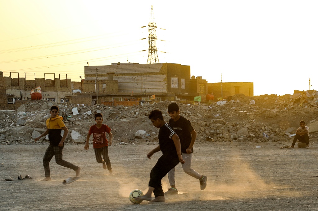 أطفال عراقيون يمارسون رياضة كرة القدم في حي فقير عند أطراف مدينة الناصرية مركز محافظة ذي قار العراقية في 25 أيلول/سبتمبر 2023 (أ ف ب)   