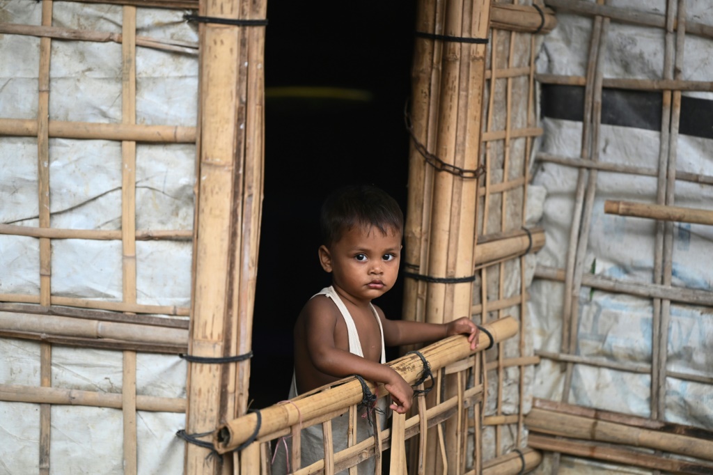    طفل من الروهينجا يقف أمام منزله المؤقت في مخيم كوتوبالونج للاجئين في بنغلاديش في 23 نوفمبر. (أ ف ب)   