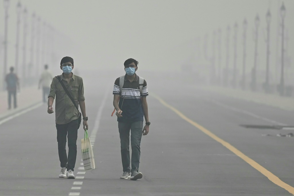 أشخاص يرتدون اقنعة طبية بسبب الضباب الدخاني في نيودلهي في 5 من تشرين الثاني/نوفمبر 2023 (أ ف ب)   