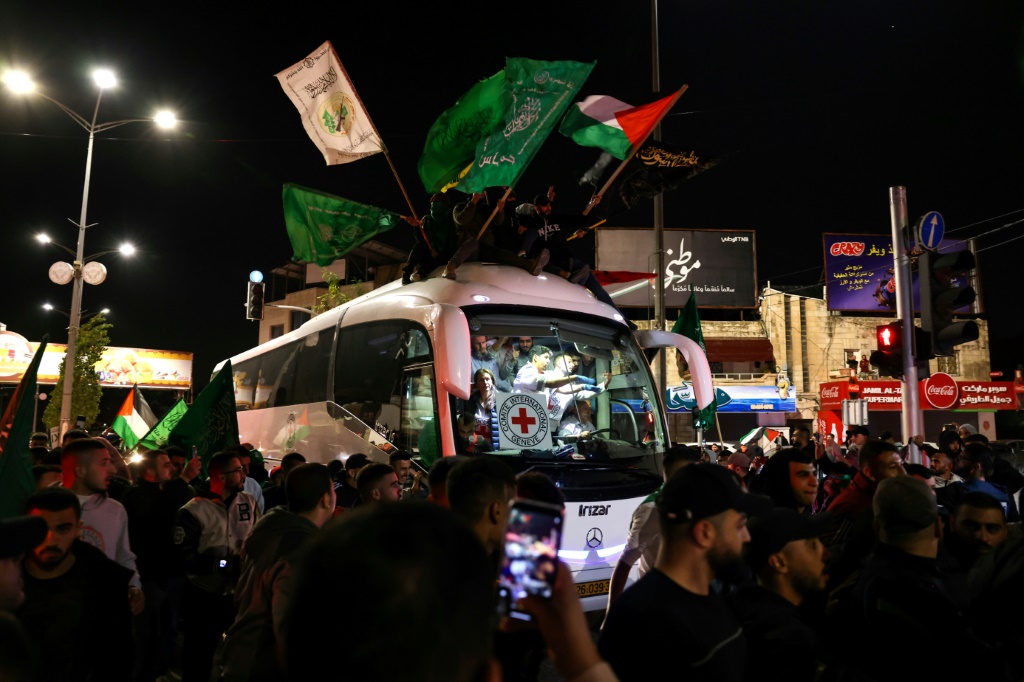 حشد يحيط بحافلة تابعة للصليب الأحمر تقل أسرى فلسطينيين محررين من السجون الإسرائيلية في رام الله بالضفة الغربية المحتلة (ا ف ب)