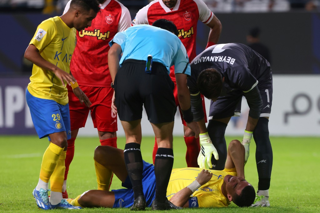 رونالدو يمسك بعنقه بعد تعرضه لاصابة خلال مباراة بيرسيبوليس (ا ف ب)