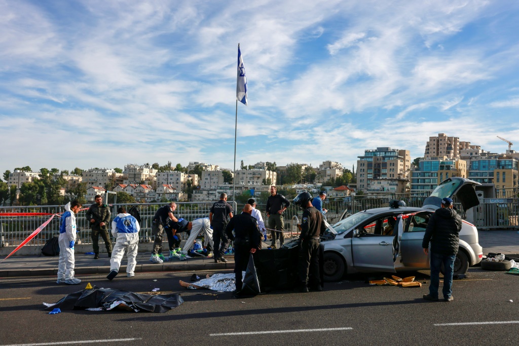 عناصر شرطة وأمن إسرائيليون يقفون قرب جثماني منفذا الهجوم في القدس الذي أسفر عن مقتل ثلاثة إسرائيليين في 30 تشرين الثاني/نوفمبر 2023 (ا ف ب)