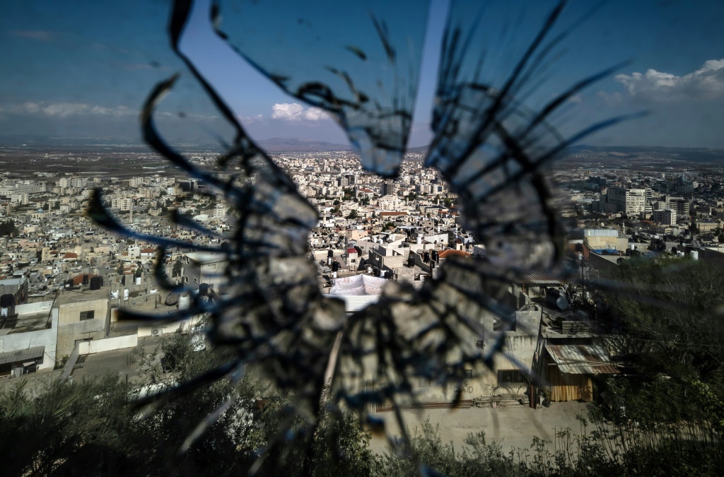 مشهد عام لمدينة جنين في صورة التقطت خلف زجاج منخور بالرصاص، في 8 تشرين الثاني/نوفمبر 2023 (ا ف ب)