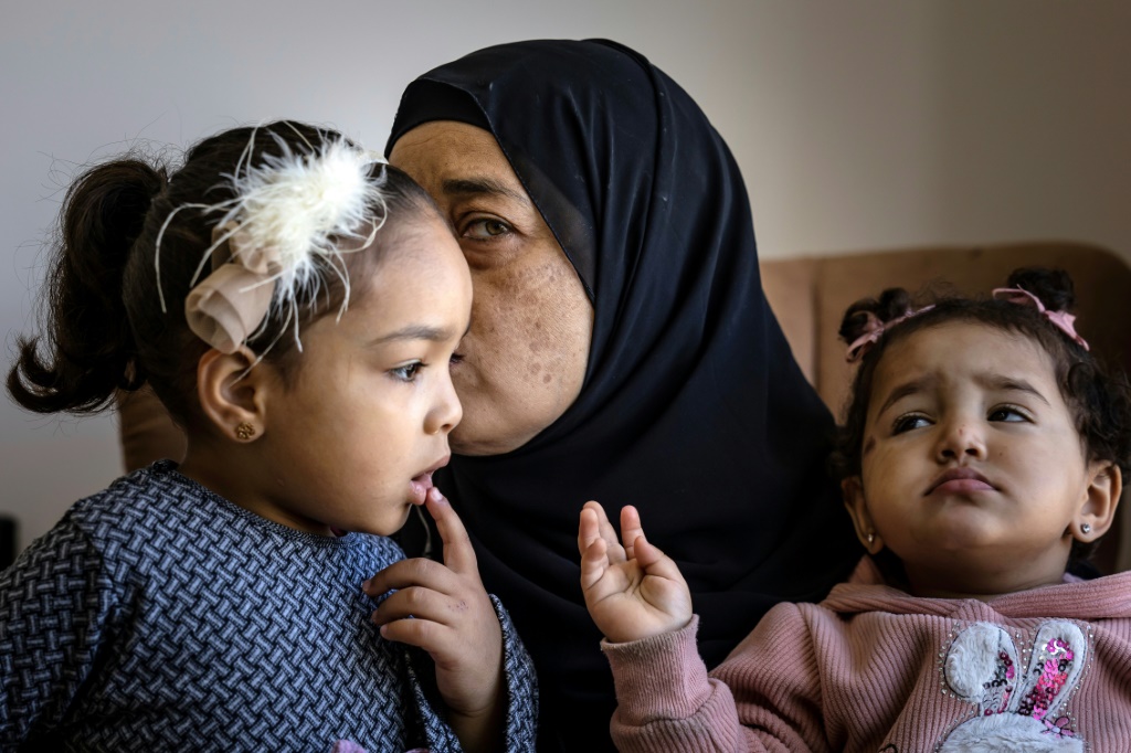  إيمان صباغ، والدة محمد صباغ الذي قتل خلال مواجهات مع الجيش الإسرائيلي في 9 تشرين الثاني/نوفمبر، تحتضن ابنتيه في منزل العائلة في جنين بالضفة الغربية المحتلة في 18 تشرين الثاني/نوفمبر 2023 (ا ف ب)