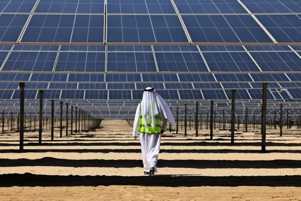 مسؤول إماراتي يسير تحت ألواح الطاقة الشمسية في محطة الظفرة للطاقة الشمسية الكهروضوئية جنوب العاصمة الإماراتية أبوظبي في 13 تشرين الثاني/نوفمبر 2023 (ا ف ب)