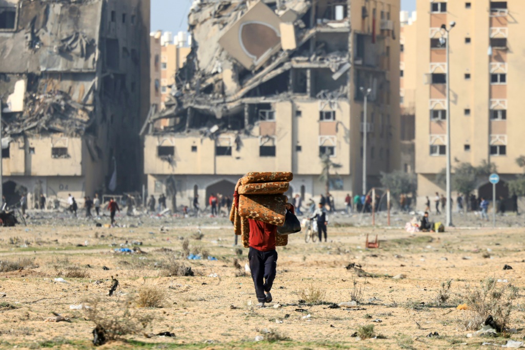 سكان في مدينة حمد السكنية في خان يونس بقطاع غزة يحملون حاجياتهم بعد قصف إسرائيلي في الثاني من كانون الأول/ديسمبر 2023 (ا ف ب)