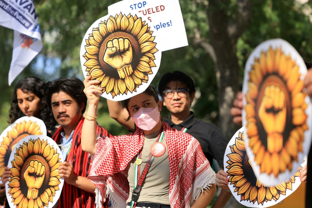 نشطاء يرفعون لافتات ضد الوقود الأحفوري خلال احتجاج في مؤتمر الأمم المتحدة للمناخ في دبي في 4 كانون الأول/ديسمبر 2023 (أ ف ب)   