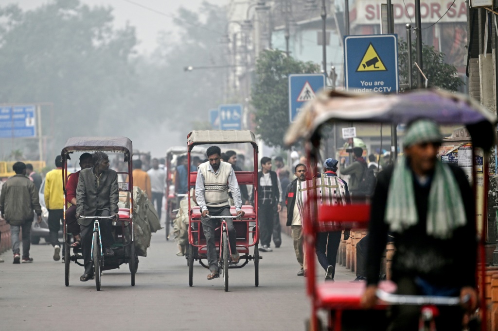 يقود رضوان عربة ريكشا عبر دلهي، العاصمة الهندية حيث سلط تلوث الهواء الضوء على الانقسامات بين الأغنياء والفقراء (أ ف ب)   